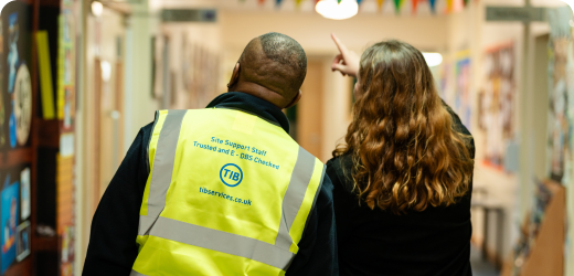 A TIB operative being shown round a school by a teacher