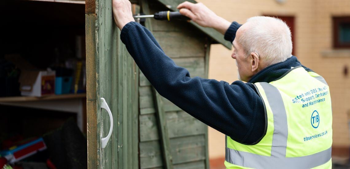 A TIB Services school caretaker fixes a school shed