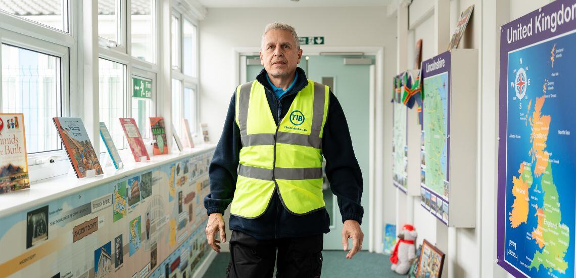 A TIB Services caretaker walks through a school corridor